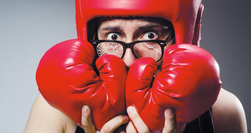 Boxer with broken glasses covers his mouth with gloves