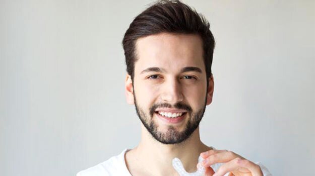 A Man Holding A bruxism nightguard In His Left Hand